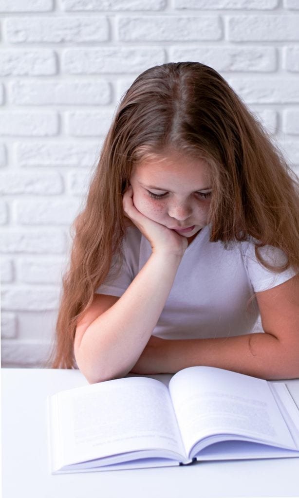 Niña estudiando aburrida