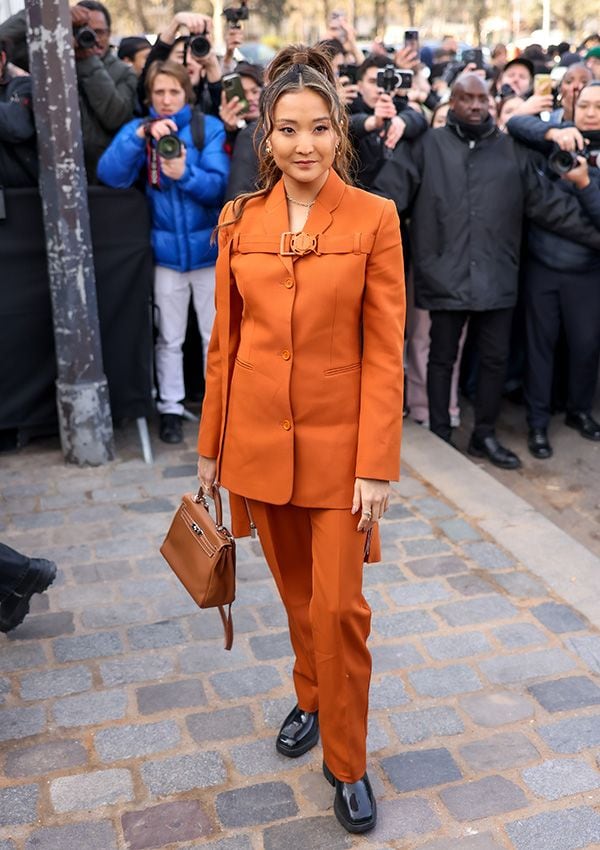 Ashley Park con traje naranja en el desfile de Off-White en París