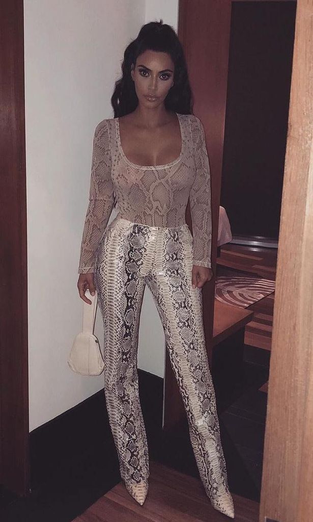 kim kardashian con top semitransparente pantalones y botas puntiagudas de snake print