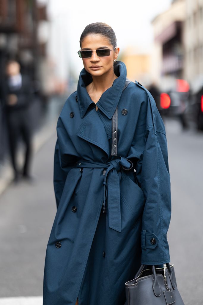  Thassia Naves luce gafas de sol negras, un maxi bolso de piel gris de Tod's y un trench verde petróleo con aplicaciones de piel en el exterior del desfile de Tod's durante la Semana de la Moda de Milán para hombre Primavera/Verano 2025 el 20 de septiembre de 2024 en Milán, Italia.