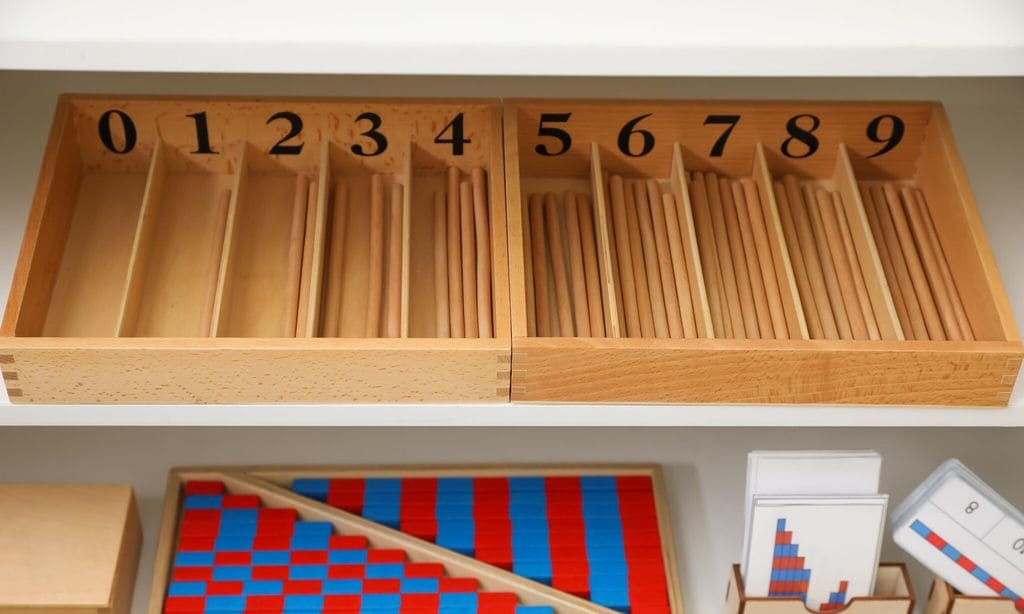 white shelving unit with different montessori toys