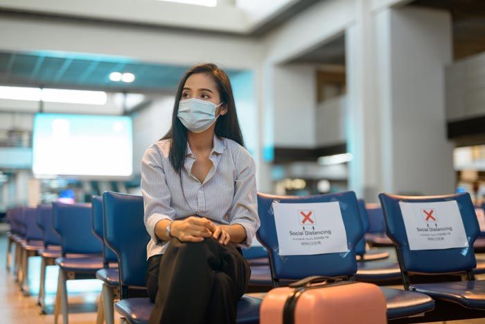 mujer en el aeropuerto con mascarilla