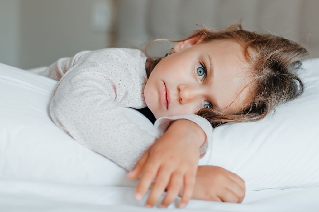 Niña con insomnio tumbada en la cama