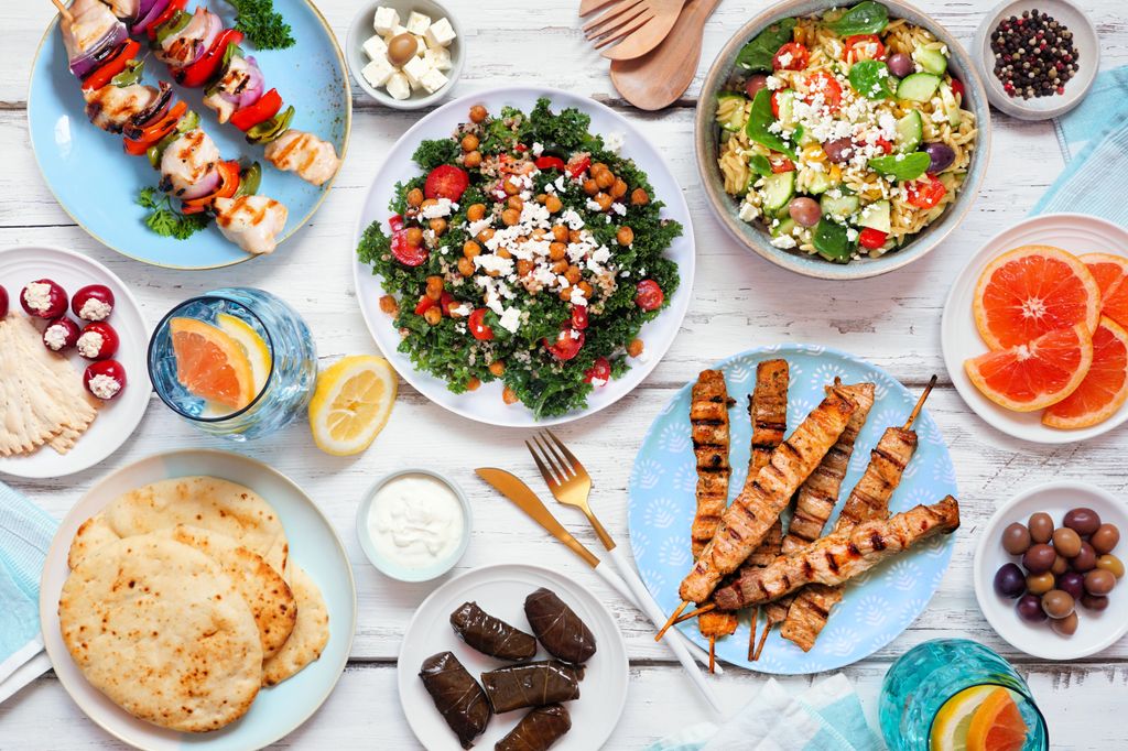 cena saludable de estilo mediterráneo, con ensaladas y brochetas