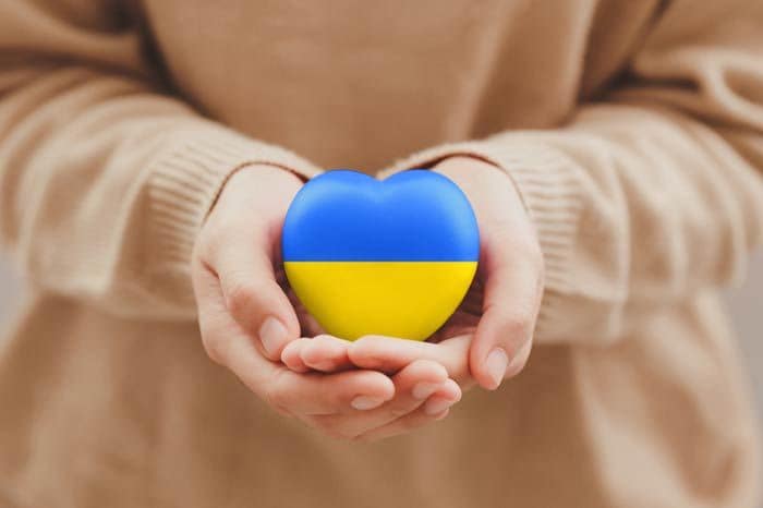 mujer con un corazón con los colores de la bandera de Ucrania