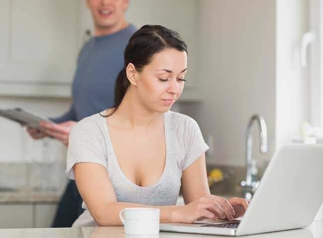 Mujer trabajando al ordenador con su pareja