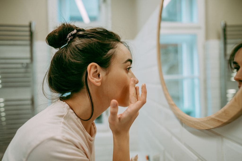 mujer joven mirándose al espejo