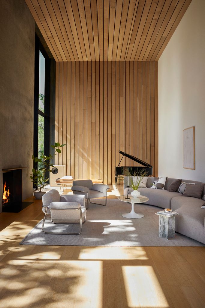 Salón decorado con sofá blanco y pared de madera