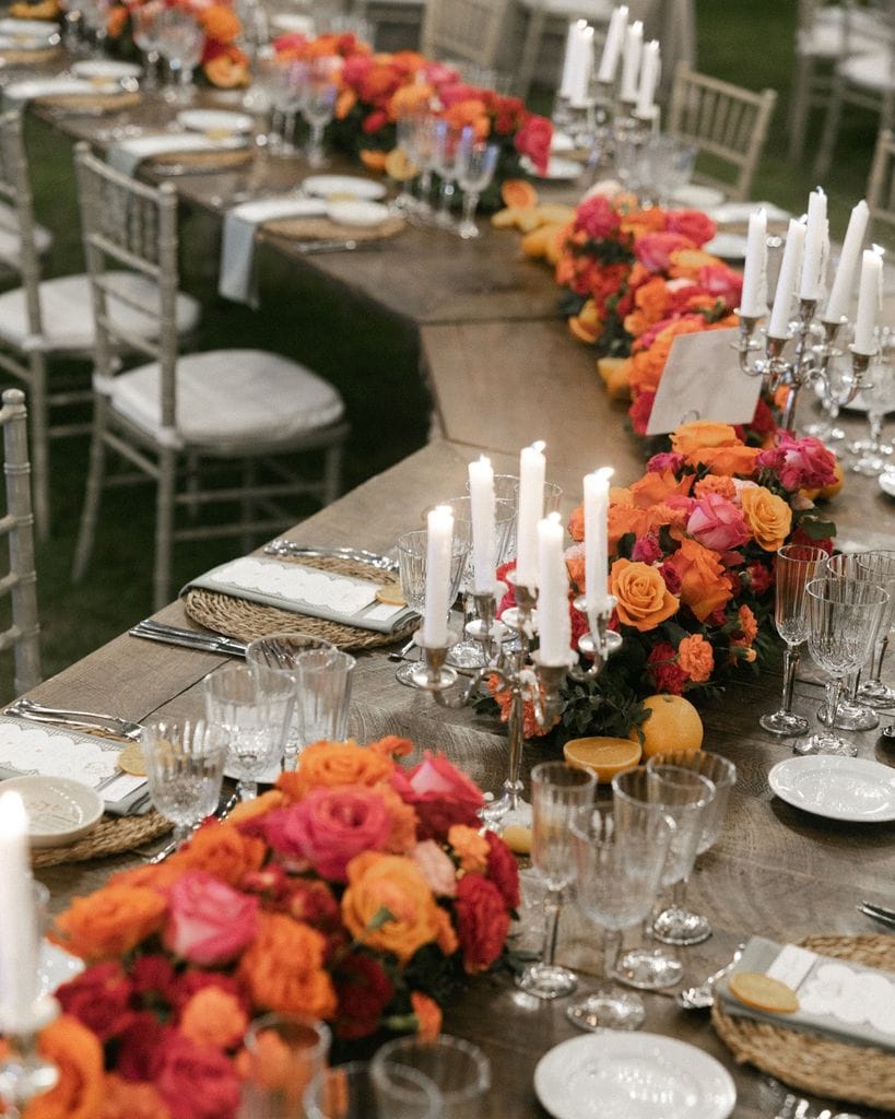 Decoración de mesas de boda con camino floral naranja