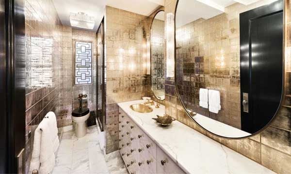 Los cuartos de baño relucen bajo los destellos del bronce y el oro, que cubre paredes y superficies. © NYC WARBURG REALTY
