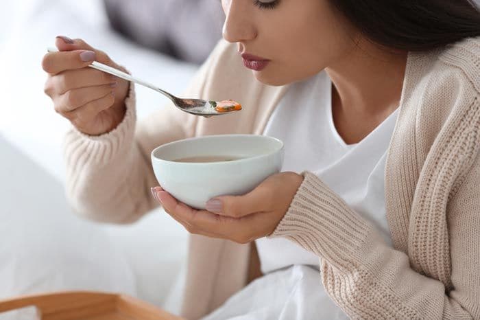 mujer tomando un caldo