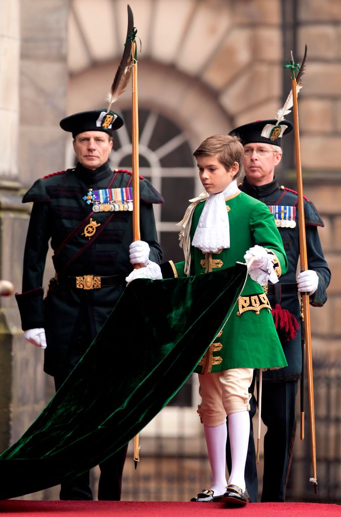 Arthur Chatto sujeta la capa de la reina Isabel II