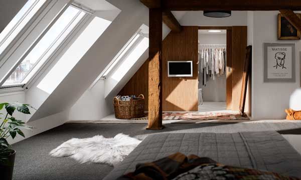 Las buhardillas son un buen lugar para establecer la habitación de invitados. Para que sea práctica, no pueden faltar, además de una cama o un sofá, un armario y una butaca. Ambiente de Velux (velux.es).
