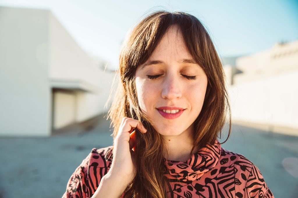 mujer con los ojos cerrados, con una sonrisa