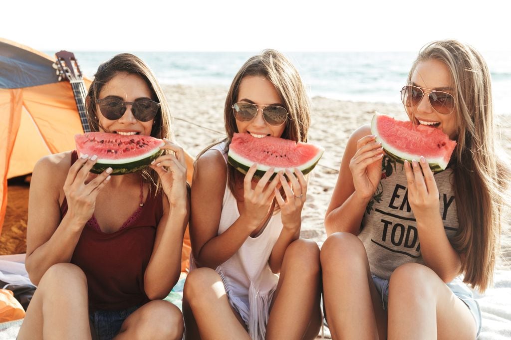 amigas comiendo sandía en la playa