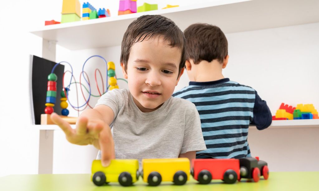 boy playing with wooden toy train