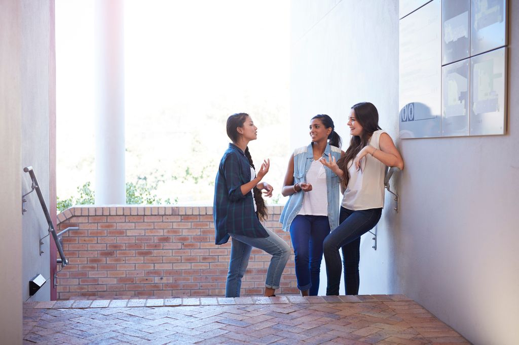 mujeres estudiantes hablando en las escaleras