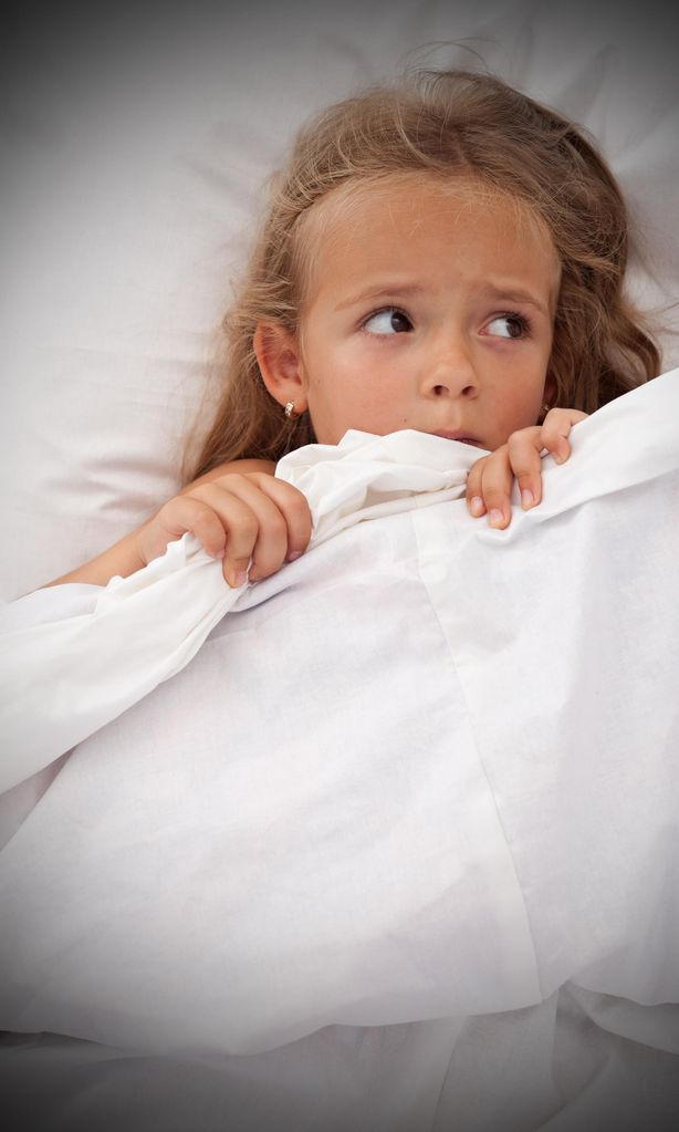 Niña asustada en la cama