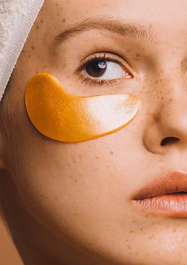 Mujer con parches de belleza en las ojeras. El formato monodosis determina el futuro de la cosmética por ser más sostenible, eficaz y práctico