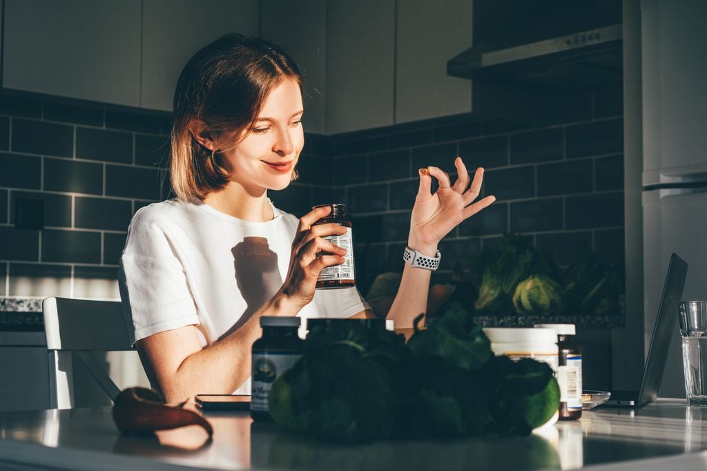 Mujer tomando suplementos alimenticios