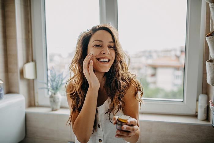 mujer aplicándose crema