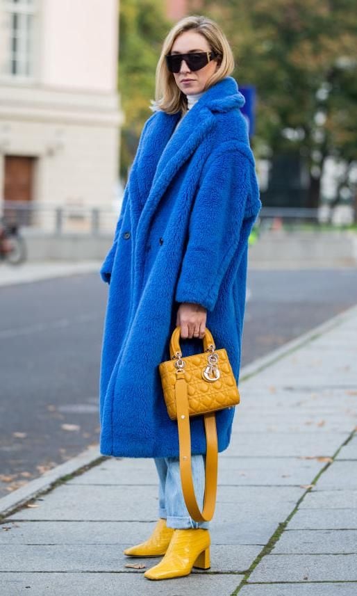 sonia lyson con botas de punta cuadrada amarillas y abrigo azul