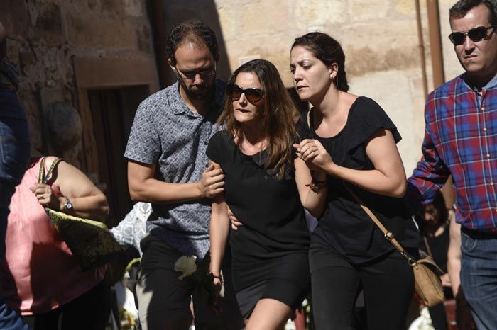 La viuda de Víctor Barrio, Raquel Sanz, de luto y tras unas oscuras gafas de sol, es ayudada a subir a la iglesia de San Bartolomé
