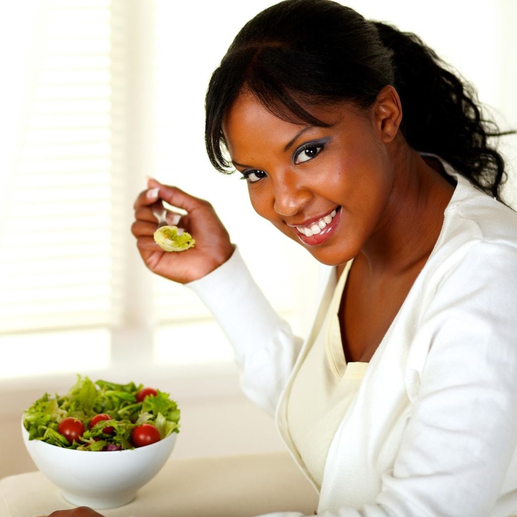 Mujer disfruta una ensalada verde