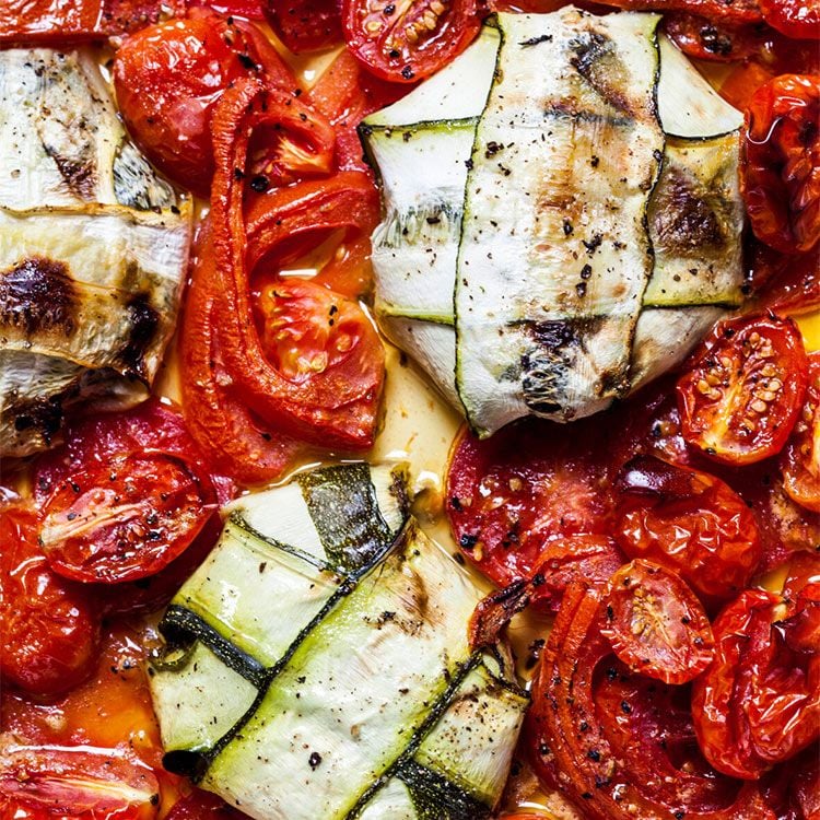 Raviolis de calabacín, queso feta y espinacas con tomates y pimientos al horno