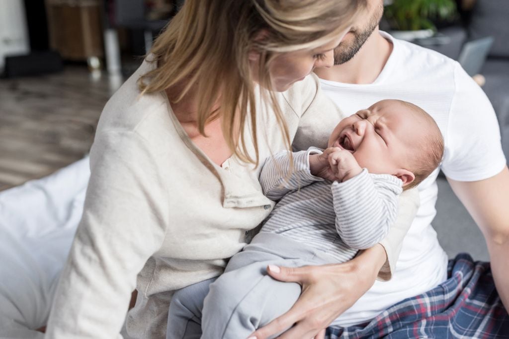 Bebé llorando en los brazos de su madre