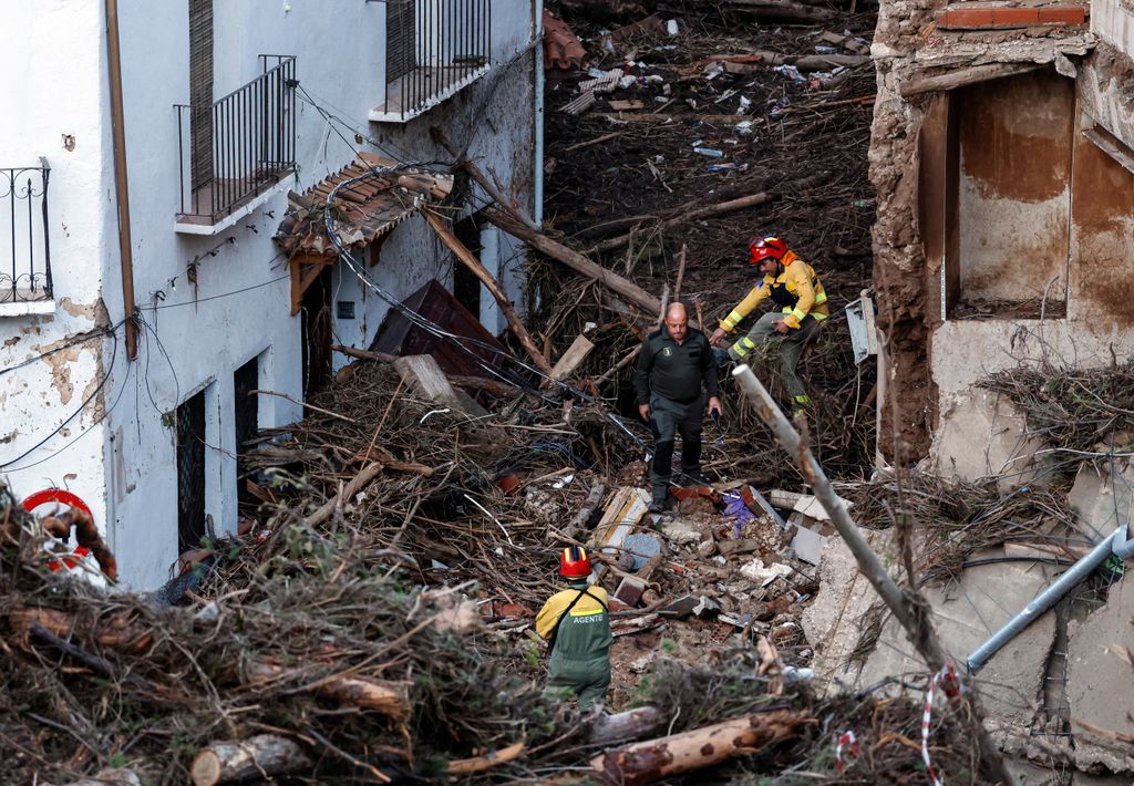 Members of the emergency services work in a devastated street on October 30, 2024 after flash floods ravaged the town of Letur, southwest of Valencia, eastern Spain. Rescuers raced on October 31, 2024 to find survivors and victims of once-in-a-generation floods in Spain that killed at least 95 people and left towns submerged in a muddy deluge with overturned cars scattered in the streets. About 1,000 troops joined police and firefighters in the grim search for bodies in the Valencia region as Spain started three days of mourning. Up to a year's rain fell in a few hours on the eastern city of Valencia and surrounding region on October 29 sending torrents of water and mud through towns and cities. (Photo by OSCAR DEL POZO / AFP) (Photo by OSCAR DEL POZO/AFP via Getty Images)