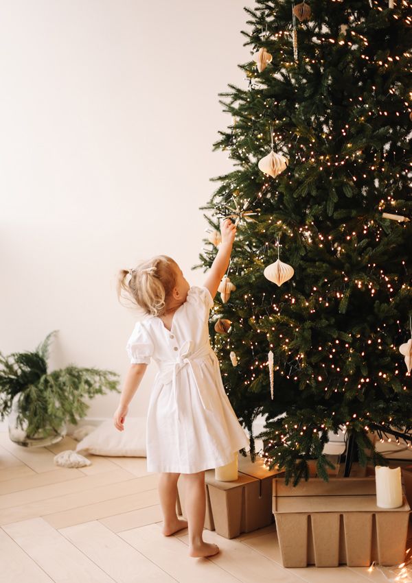 Niña decorando el árbol de Navidad