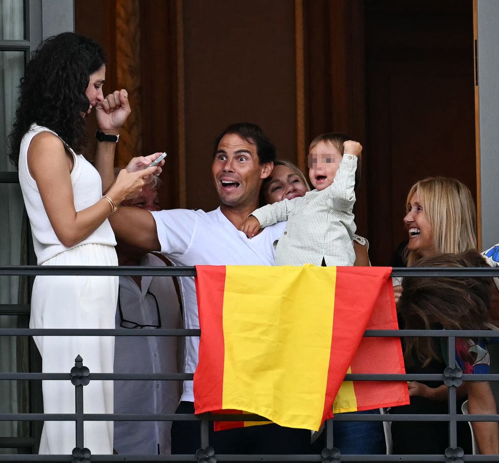 Rafa Nadal con su mujer y su hijo reaccionando desde un balcón a la gala de apertura de los JJOO 2024