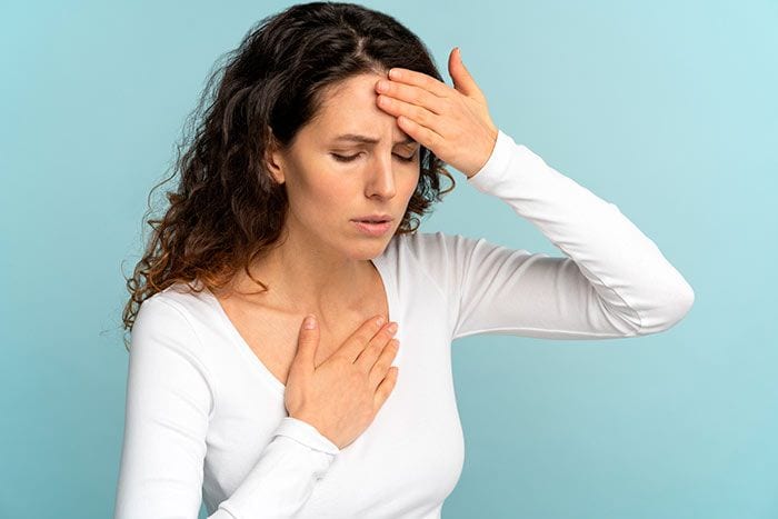 mujer con la mano en la cabeza y en el pecho