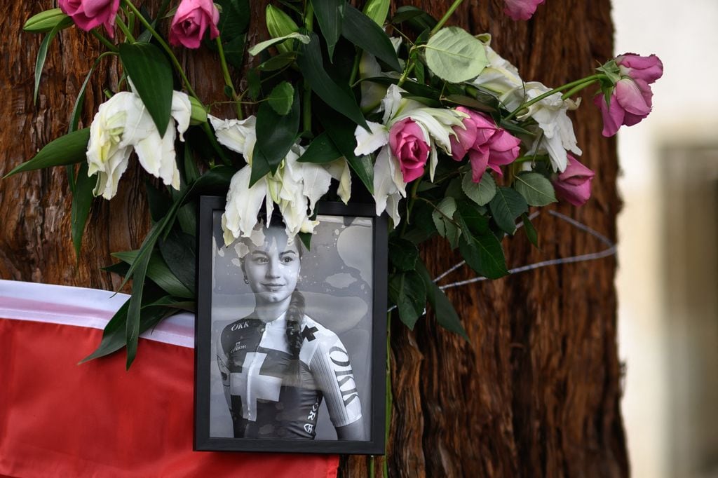 Photo of Muriel Ferrer next to the Swiss flag and bouquets of flowers