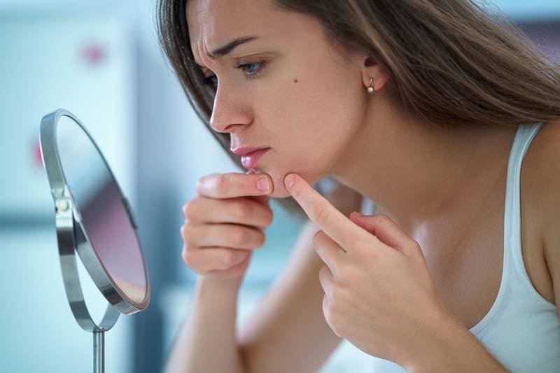 mujer toca rostro