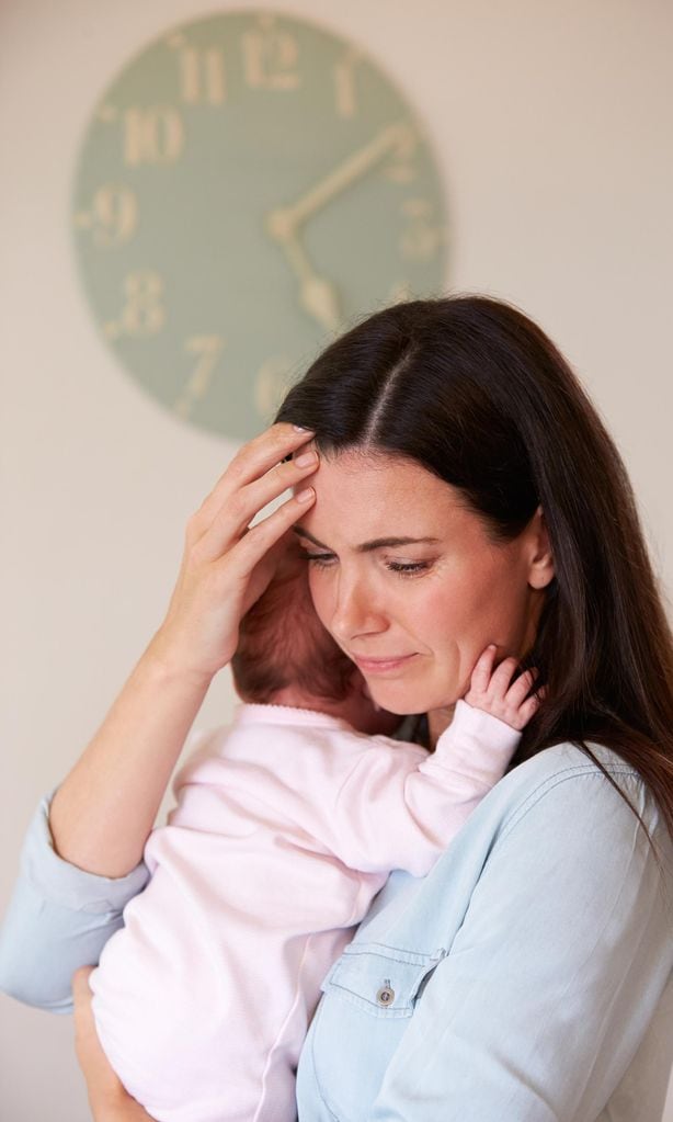 Mamá triste con su bebé en brazos