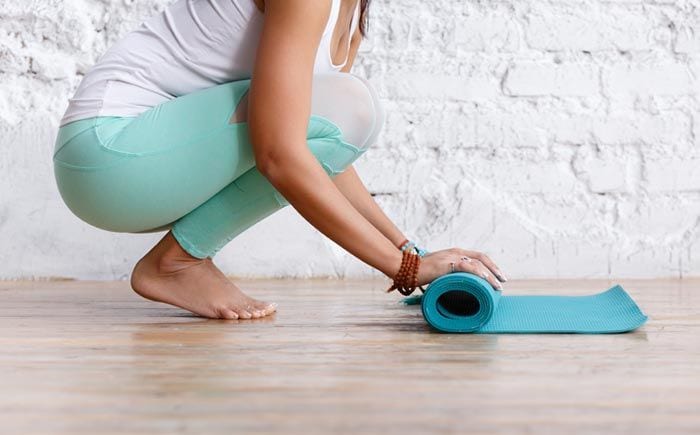 mujer con la esterilla de yoga