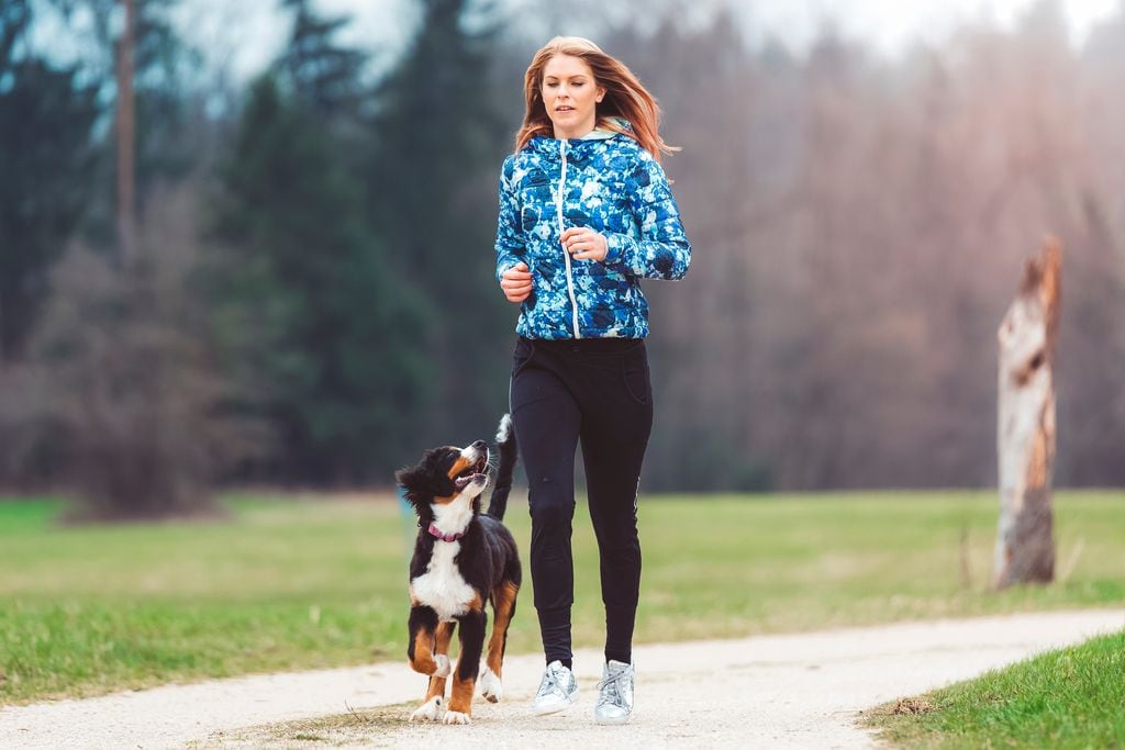 Una chica corriendo con su perro