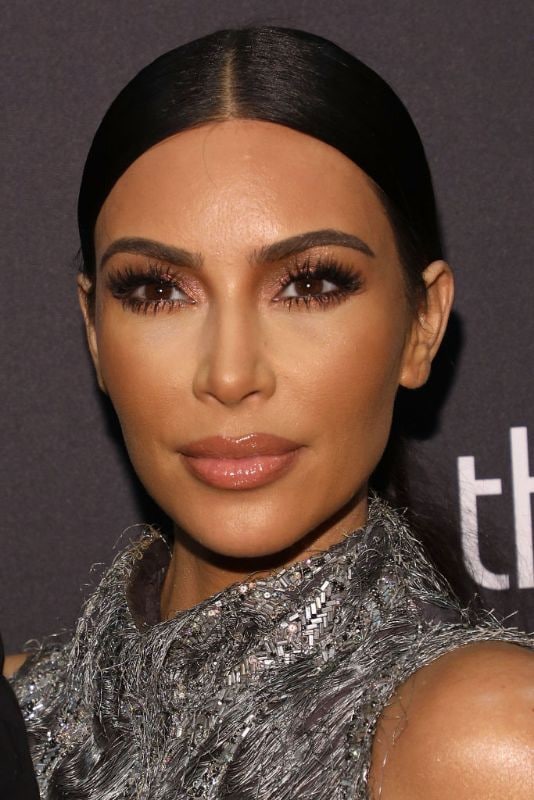 Kim Kardashian con labios glossy, cabello recogido y vestido plateado 