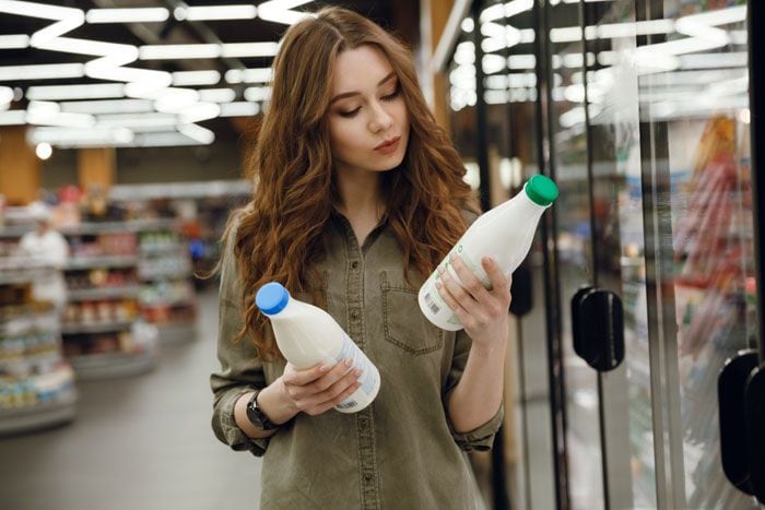 mujer mirando botellas de leche