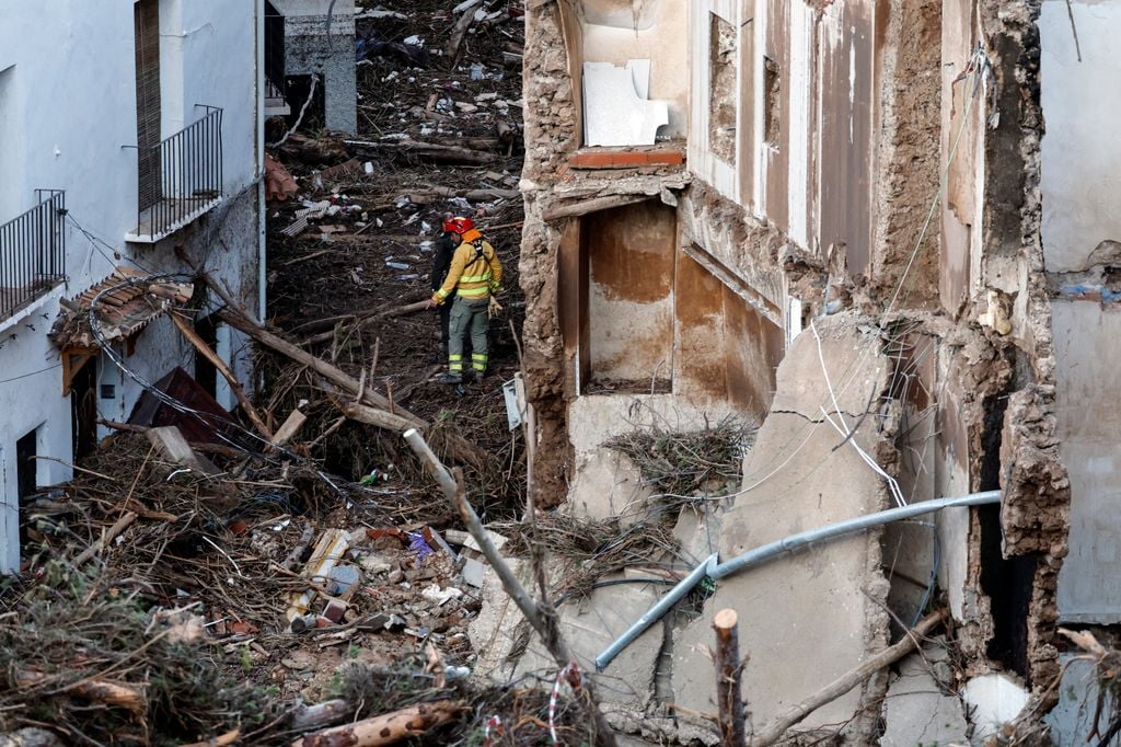 Members of the emergency services work in a devastated street on October 30, 2024 after flash floods ravaged the town of Letur, southwest of Valencia, eastern Spain. Rescuers raced on October 31, 2024 to find survivors and victims of once-in-a-generation floods in Spain that killed at least 95 people and left towns submerged in a muddy deluge with overturned cars scattered in the streets. About 1,000 troops joined police and firefighters in the grim search for bodies in the Valencia region as Spain started three days of mourning. Up to a year's rain fell in a few hours on the eastern city of Valencia and surrounding region on October 29 sending torrents of water and mud through towns and cities. (Photo by OSCAR DEL POZO / AFP) (Photo by OSCAR DEL POZO/AFP via Getty Images)