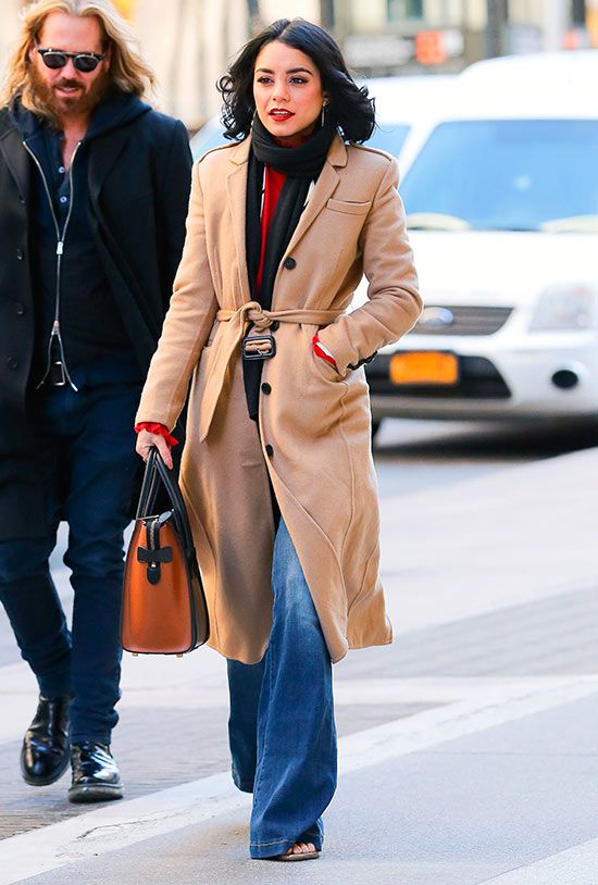 Los pantalones de campana se convierten en una buena pareja de baile para el abrigo camel. Fíjate en cómo lo lleva nuestra protagonista, con una blusa roja y un cardigan o chaqueta blanca; y en los complementos: un bolso tricolor de Céline Paris y un pañuelo negro; vas a verlos en prácticamente todas las fotos de esta galería.
