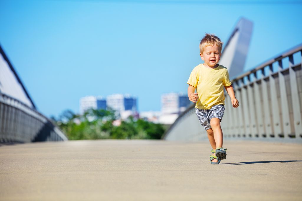 Niño pequeño corriendo solo por la calle