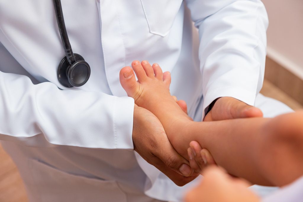 Pediatra examinando los pies de un niño