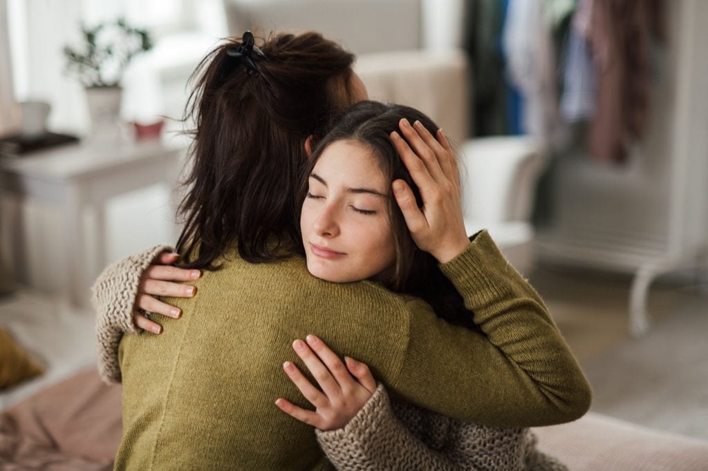 Adolescente consolada por su madre