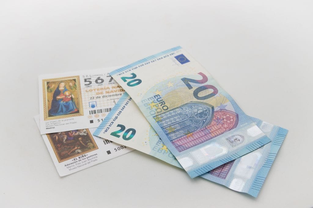 billetes de 20 euros junto con décimos de lotería de Navidad