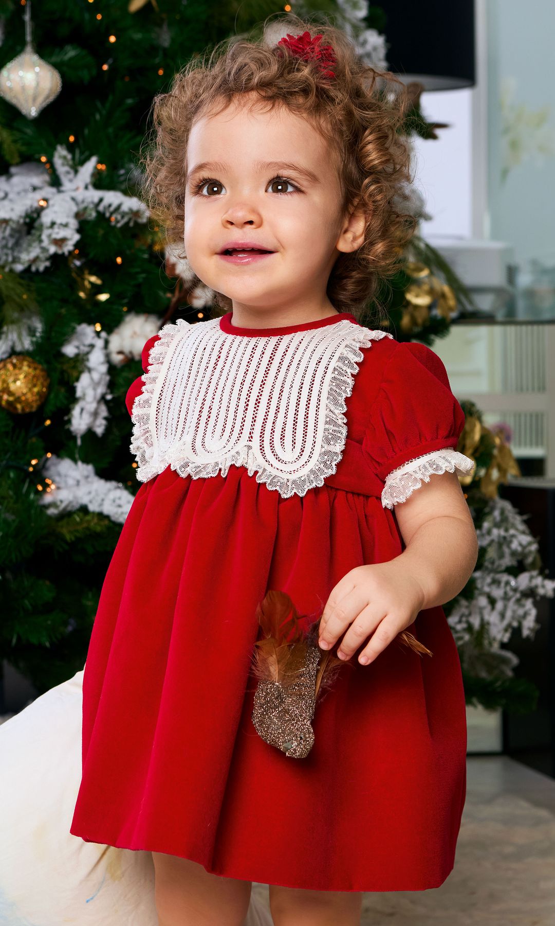 Anita, cogiendo con la mano uno de los adornos del árbol de la Navidad