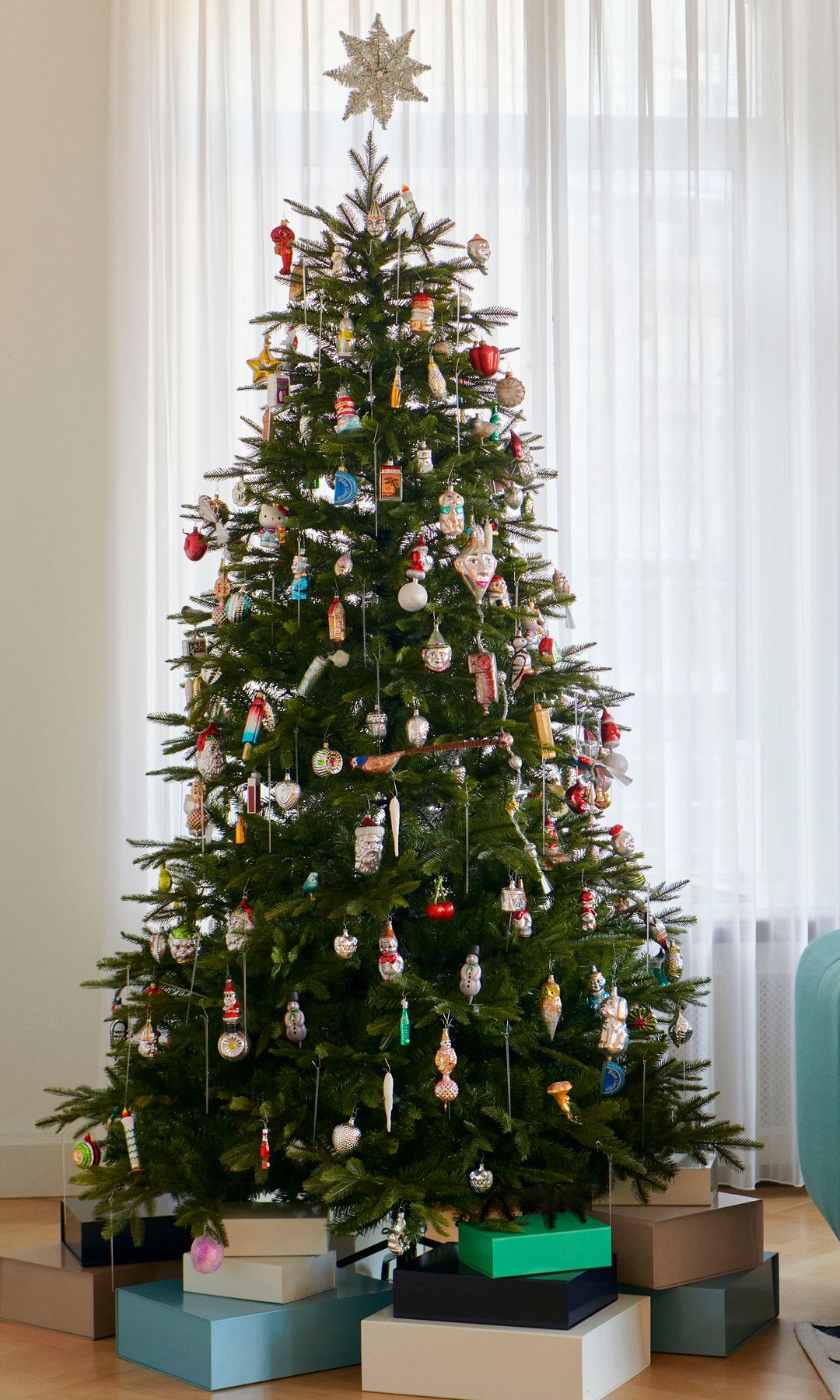 Árbol de Navidad con regalos y decorados con figuras de colores 