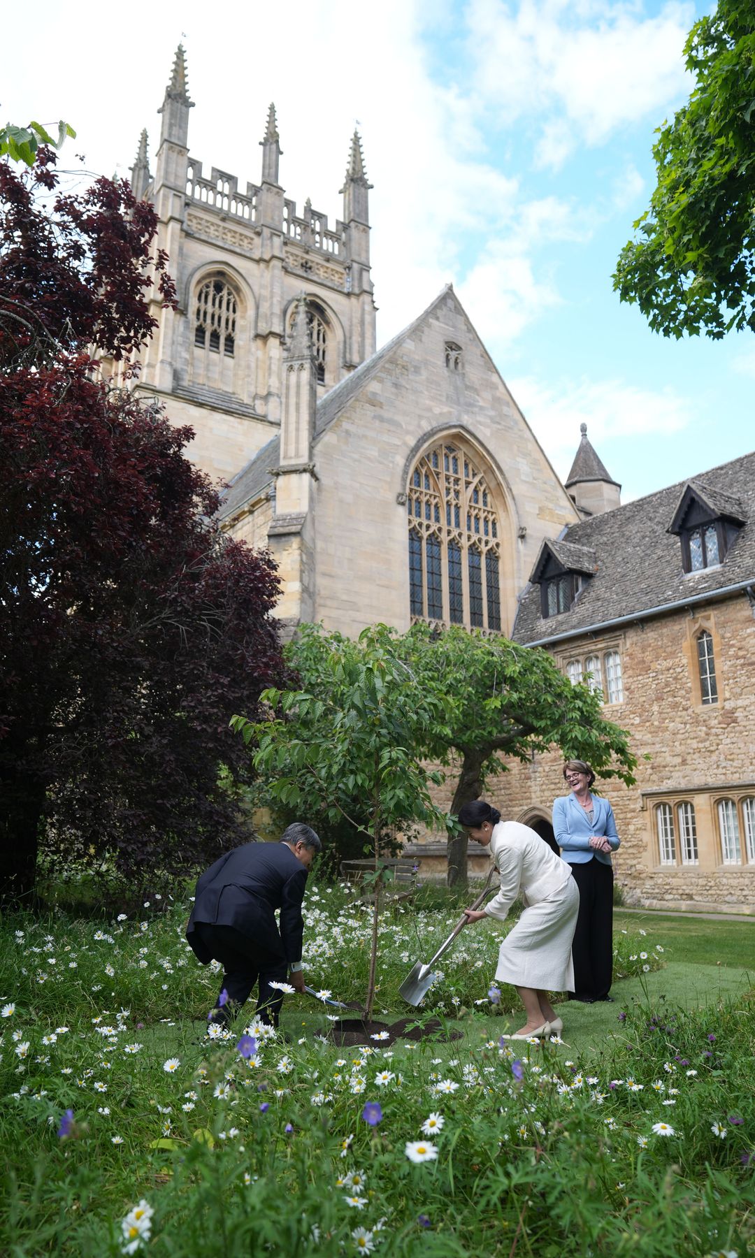 Naruhito y Masako de Japón plantando un cerezo durante su visita a Merton College en Oxford